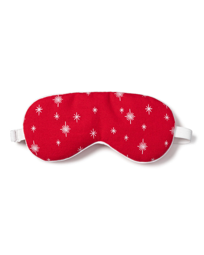 The Adults Flannel Sleep Mask in Starry Night by Petite Plume, featuring white stars on red and an adjustable strap, makes a perfect gift. Pair it with matching eye masks for added thoughtfulness.