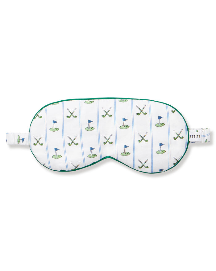 The Adult's Pima Sleep Mask in Fairway Stripe is a white sleep mask with green trim, decorated with golf clubs, balls, and putting greens. It features an adjustable strap and a small side tag.