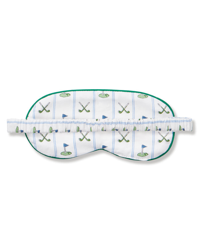 The Adult's Pima Sleep Mask in Fairway Stripe is a white sleep mask with green trim, decorated with golf clubs, balls, and putting greens. It features an adjustable strap and a small side tag.