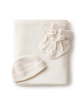 The Baby Cashmere Bundle in Ivory—featuring a folded knit blanket, matching baby hat, and bow-adorned booties—all made from soft cashmere, is arranged on a white background.