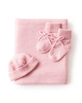 The Baby Cashmere Bundle in Rose features a neatly folded pink baby blanket, matching knit booties, and a ribbed knit hat, all displayed on a white background.