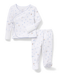 The Baby Pima Wrap Set in Letters and Lullabies features white pajamas with blue trim, including a wrap-style top with a side tie closure and matching pants. Both pieces are adorned with a blue and brown alphabet and bear print.