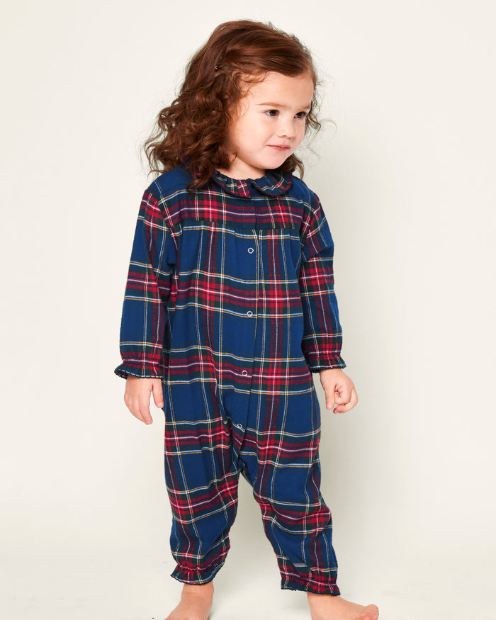 Close-up of the Babys Brushed Cotton Madeline Romper in Windsor Tartan by Petite Plume, featuring a plaid design with red, green, and blue colors, a ruffled collar, and snap buttons. The label ensures it is chemical-free for comfort and peace of mind.