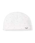 A white baby hat from Petite Plume features soft Peruvian Pima cotton with gray star patterns. It has a folded brim and a small embroidered gray logo of two leaves, representing premium soft baby clothing.
