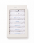 A box labeled “Baby’s Pima Long Sleeve Onesie Set in French Lessons Blue” contains seven folded white onesies, each embroidered with the days of the week in French: lundi, mardi, mercredi, jeudi, vendredi, samedi, and dimanche.