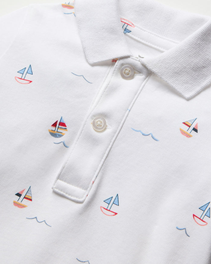 White baby romper with sailboat pattern on a white background