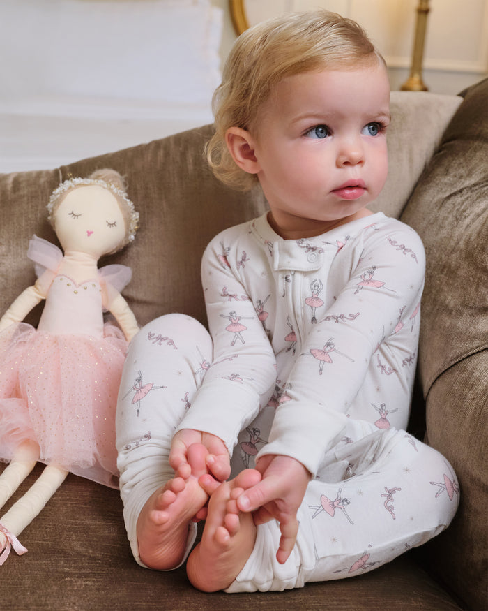 The Baby's Pima Peekaboo Romper in Sugar Plum Fairy is a long-sleeve white onesie featuring a front zipper, pink ballerina and flower prints, plus solid white cuffs and ankles.