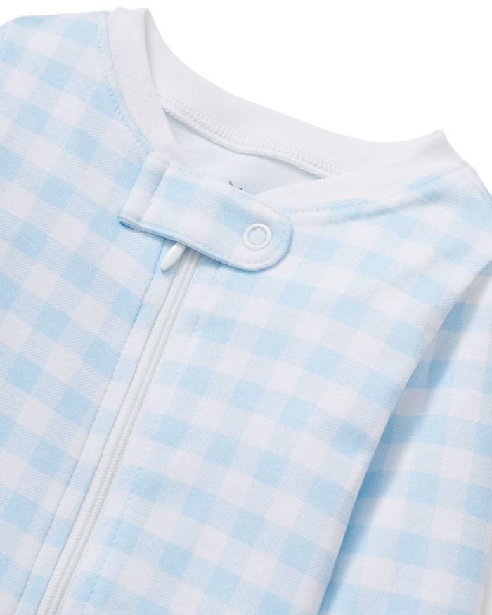 Close-up of the Baby’s Pima Romper in Light Blue Gingham, featuring a light blue and white checkered pattern, a white zipper, and a snap button tab at the collar.