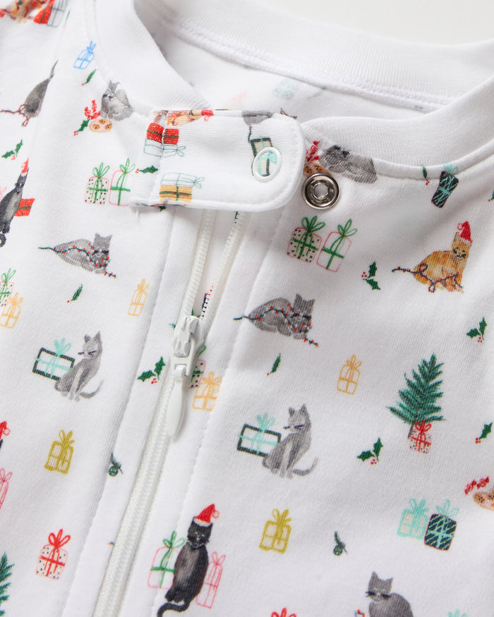The Baby's Pima Romper in Merry Meow is a white onesie with a front zipper, covered feet, long sleeves, and playful prints of animals, trees, and people enjoying outdoor adventures like camping and fishing.