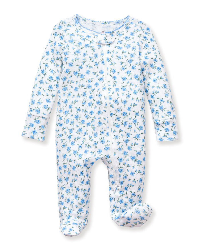 The Baby's Pointelle Footie Romper in Blue Floral is a white footed onesie with a front zipper, decorated with small blue flowers and green leaves.