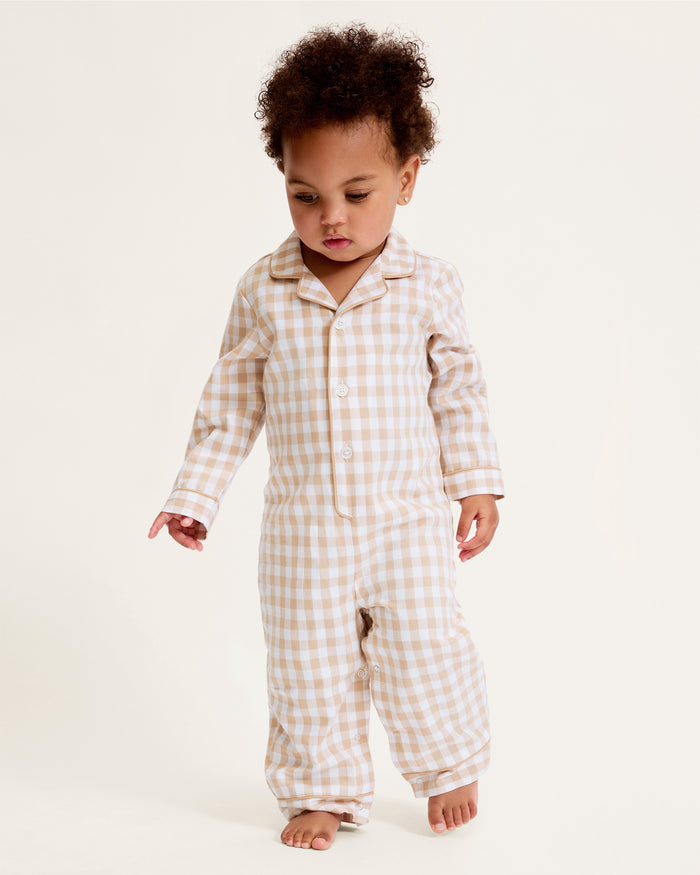 The Baby's Twill Classic Romper in Camel Gingham features long sleeves, a beige and white gingham check pattern, front buttons, snap closures at the legs, a collar, and cuffed sleeves and legs.