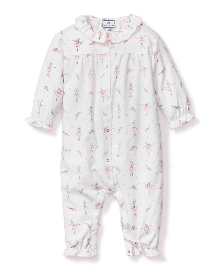 The Petite Plume Babys Flannel Madeline Romper in Sugar Plum Fairy features a white onesie with pink ballerina and bunny prints made of flame-retardant fabric. It includes a ruffled collar and cuffs, snap closures down the front and legs, making it perfect for childrens sleepwear.