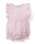 A toddler with curly hair wears the Baby's Twill Ruffled Romper in Peony Plaid, featuring ruffled sleeves, standing barefoot against a plain light background and looking slightly to the side.