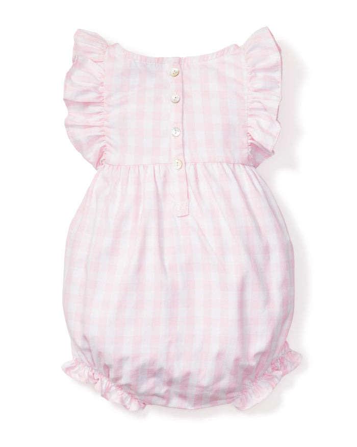 The Babys Twill Ruffled Romper in Pink Gingham by Petite Plume features ruffled sleeves and leg openings, doubling as cozy sleepwear. The back has a row of white buttons down the upper section.