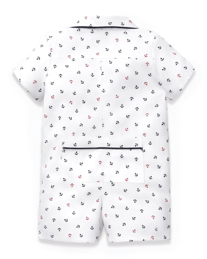 Baby’s Twill Summer Romper in Anchors Away White is a white short-sleeve romper with a blue and red nautical anchor print, featuring a collar and a back pocket accented with navy trim. The outfit is displayed flat to showcase the back side.