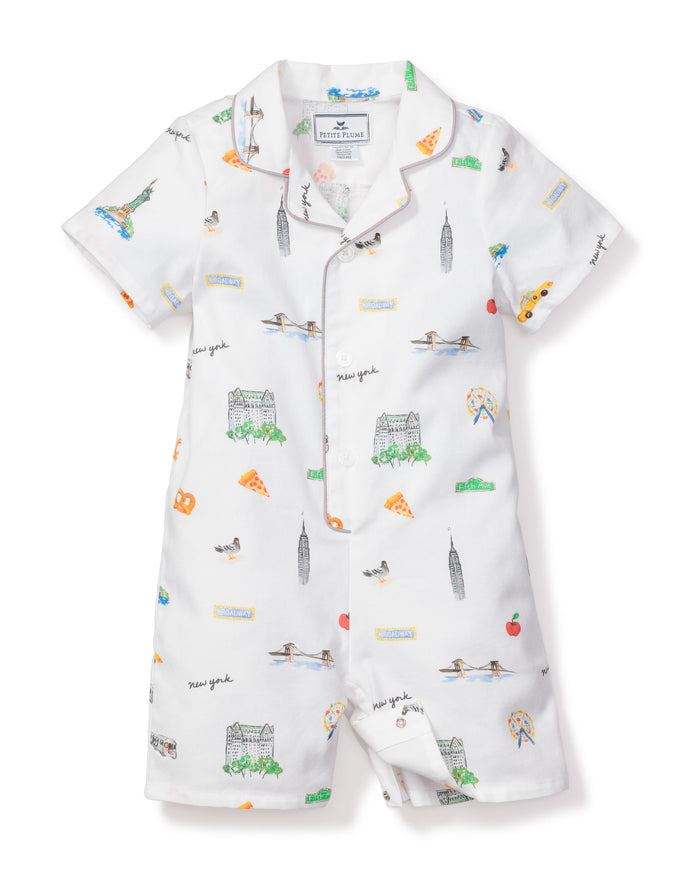 The Babys Twill Summer Romper in New York! New York! by Petite Plume is crafted from yarn-dyed cotton and adorned with colorful NYC illustrations, including the Statue of Liberty and Empire State Building. It features short sleeves, a collar, and snap closure—ideal for little city dreamers.