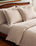 The Luxe Premium Percale Duvet Set in Camel Gingham features two pillows and a folded comforter with a beige and white gingham check pattern, neatly stacked on a white background.