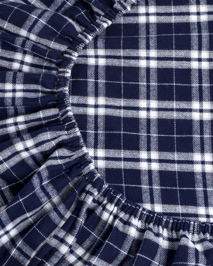 A close-up of the Flannel Crib Sheet in Oxford Tartan, showcasing its navy blue and white plaid fabric with evenly spaced vertical and horizontal stripes in a classic checkered design.