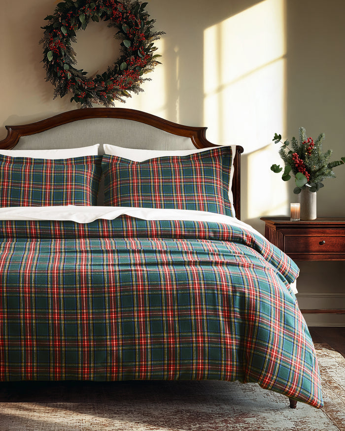 The Flannel Duvet Set in Kensington Tartan features a green, red, and white plaid pattern and includes a comforter and two pillows, all neatly folded against a white background.