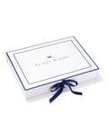 The Petite Plume Gift Box, ideal for any occasion, features a white design with a blue border and Petite Plume centered. A small bird logo is above the text, and its elegantly finished with a neatly tied blue ribbon on the right. Perfect for enhancing any purchase.