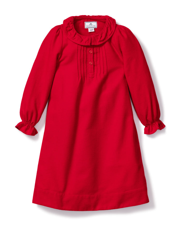 The Girls Flannel Victoria Nightgown in Red by Petite Plume features a ruffled collar and cuffs. Made from flame-retardant fabric with vertical pleats on the bodice, this soft, elegant piece combines safety and style for various occasions.