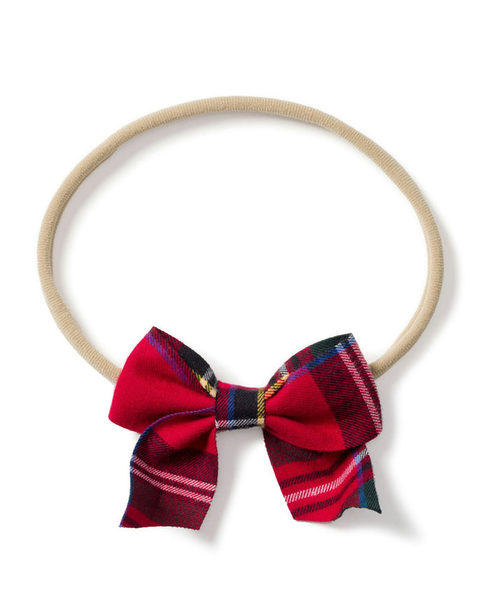 The Girls Hair Bows in Imperial Tartan by Petite Plume is a beige circular headband with a plaid bow in festive red, black, and white. Perfect as a holiday gift or stocking stuffer, it adds an elegant touch to any occasion against its white background.