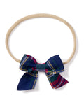 Petite Plumes Girls Hair Bows in Windsor Tartan, featuring a beige elastic headband with a dark blue, green, and red plaid fabric bow, make perfect stocking stuffers or holiday gifts for fans of girls hair bows.