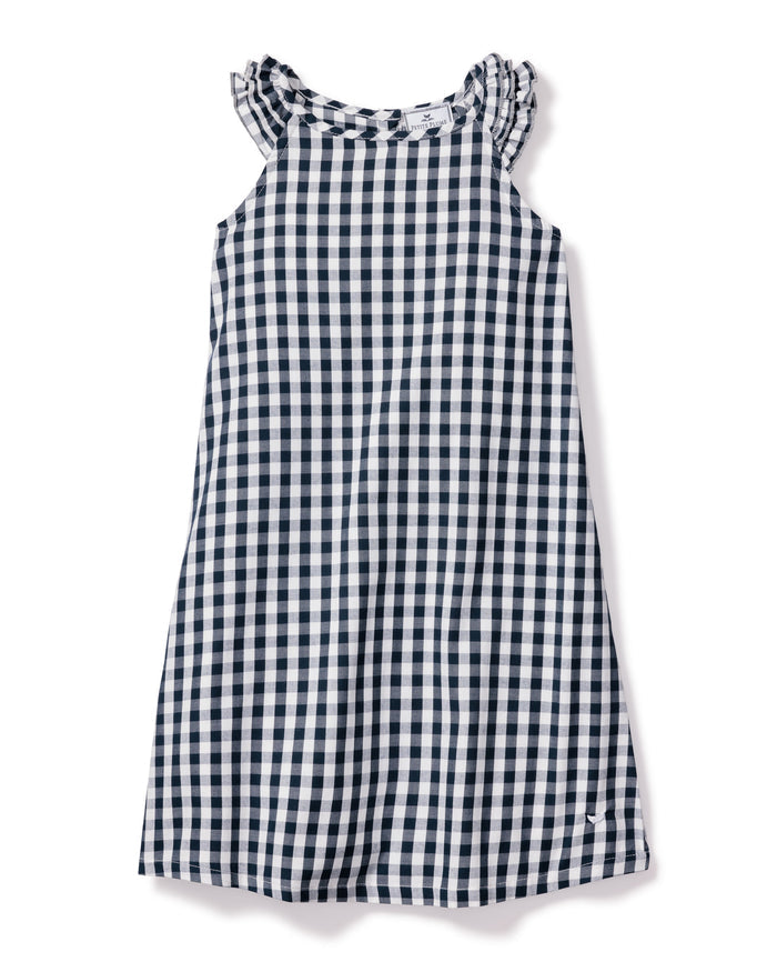 The Girls Twill Amelie Nightgown in Navy Gingham by Petite Plume is a sleeveless cotton dress with a navy and white check pattern. It has a round neck with subtle ruffle detailing for added charm.