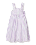 The Girls Twill Charlotte Nightgown in Lavender French Ticking by Petite Plume showcases a sleeveless design with vertical purple stripes on white, crafted from yarn-dyed cotton. It features a ruffled neckline, button chest details, and wide shoulder straps for an enchanting look.