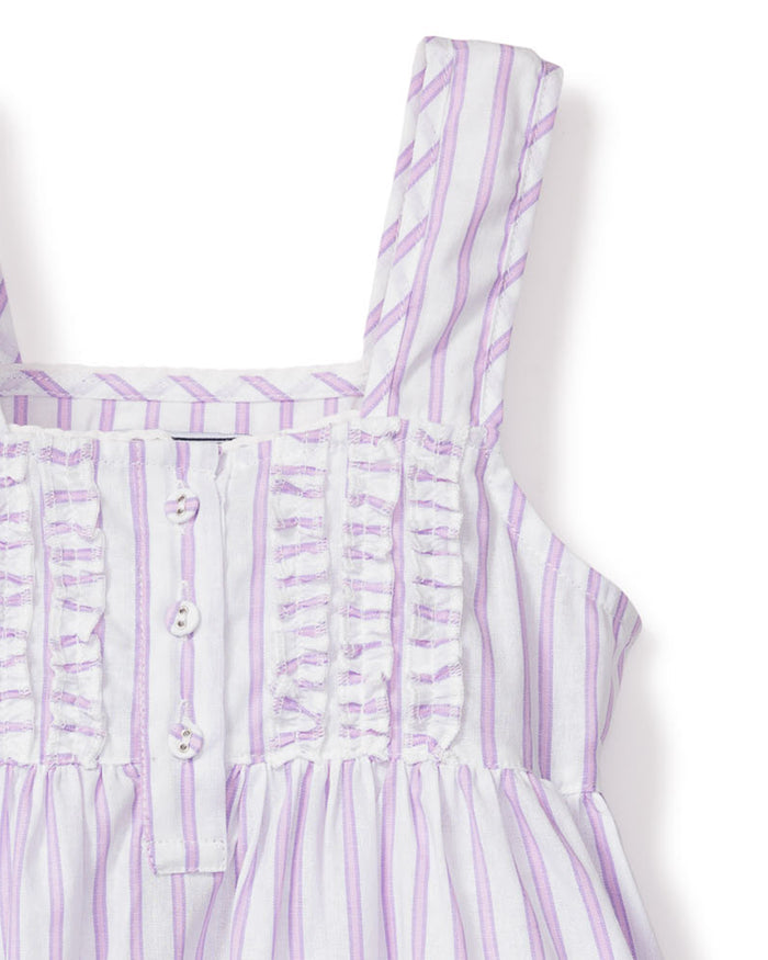 Close-up of Petite Plumes Girls Twill Charlotte Nightgown in Lavender French Ticking, crafted from yarn-dyed cotton with vertical lavender and white stripes. It features a ruched bodice with decorative buttons and soft-textured shoulder straps for a refined look.