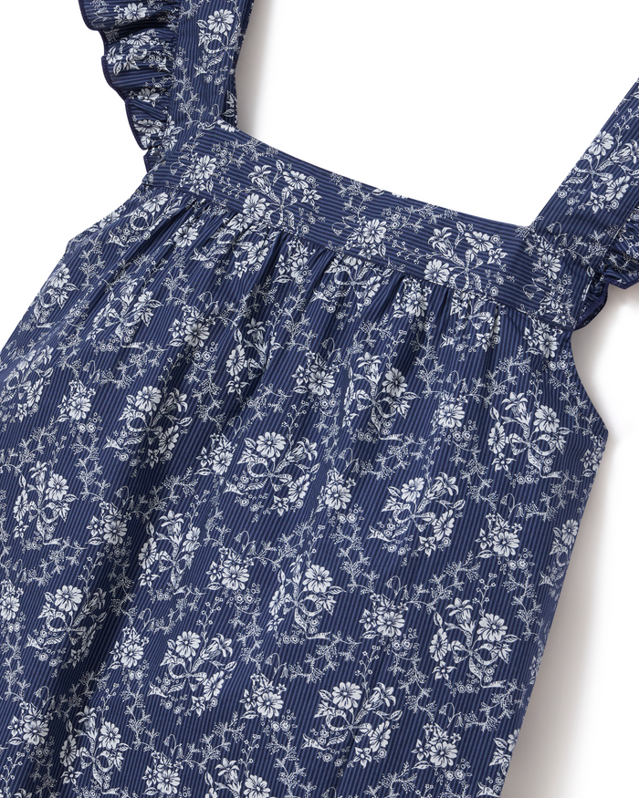Close-up of the Girl’s Twill Clara Short Set in Innkeeper Trellis, featuring a blue fabric with white floral patterns and wide ruffled shoulder straps, gathered at the top.