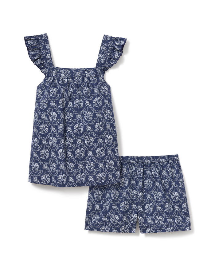 Girl’s Twill Clara Short Set in Innkeeper Trellis featuring a blue floral pattern with a ruffled-sleeve top and coordinating elastic-waist shorts, displayed on a white background.