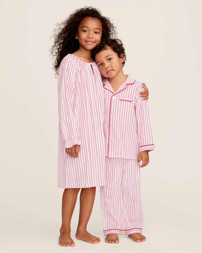 Close-up of Petite Plumes Girls Twill Delphine Nightgown in Antique Red Ticking, featuring pink and white stripes with red stitched ruffles and an embroidered star. Ideal for childrens sleepwear, its smooth texture highlights the detailed pattern and craftsmanship.