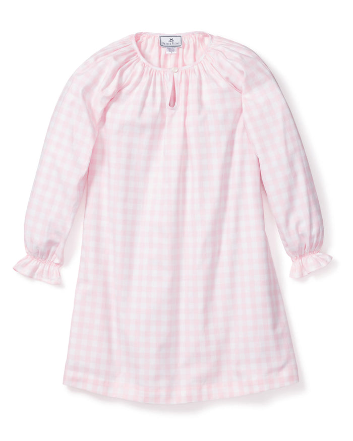 The Petite Plume Girls Twill Delphine Nightgown in Pink Gingham features long sleeves, a rounded neckline with a small keyhole opening, and ruffled cuffs, made from flame-retardant fabric.