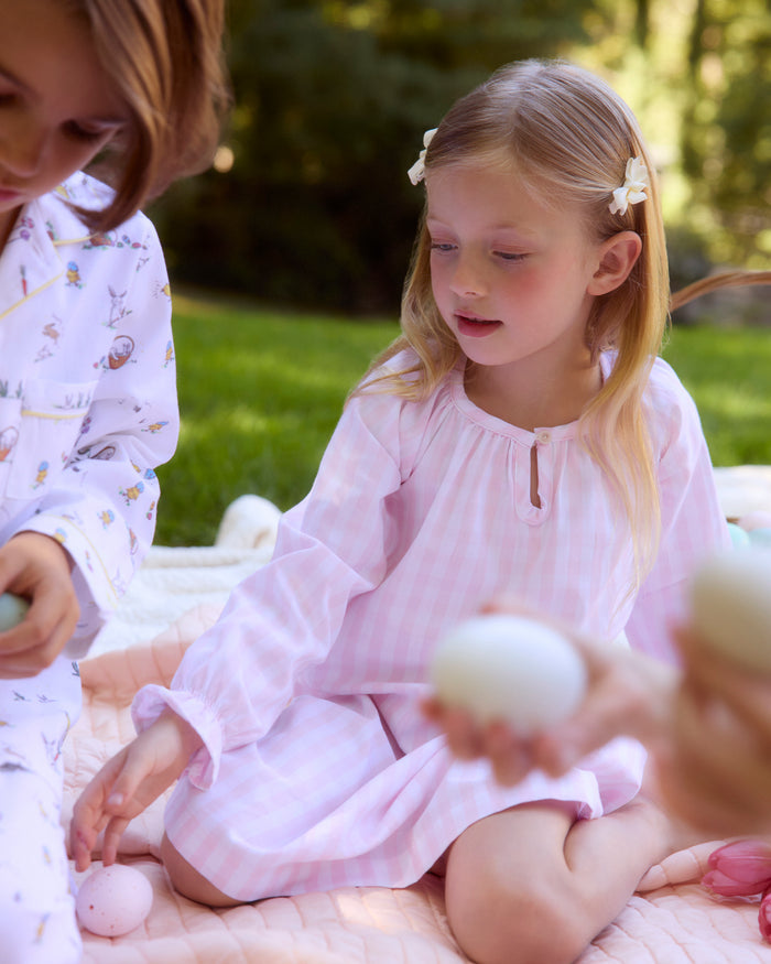 The Petite Plume Girls Twill Delphine Nightgown in Pink Gingham features long sleeves, a rounded neckline with a small keyhole opening, and ruffled cuffs, made from flame-retardant fabric.