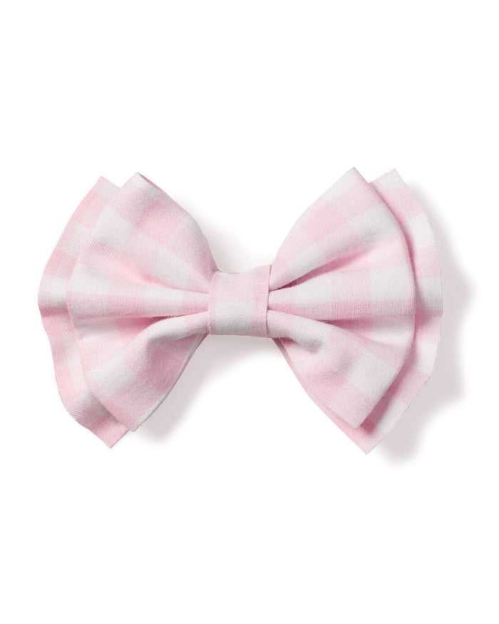 The Girls Twill Hair Bow in Pink Gingham by Petite Plume is a charming accessory crafted from folded fabric resembling a butterfly. Its pastel hues and simple design, set against a white background, make it perfect for girls hair.