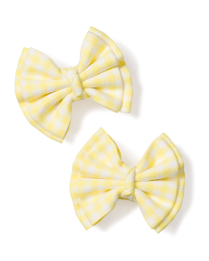 Two Petite Plume Girls Twill Hair Bows in Yellow Gingham, exuding the cozy charm of pajamas with their textured appearance, rest slightly offset from each other on a white background.