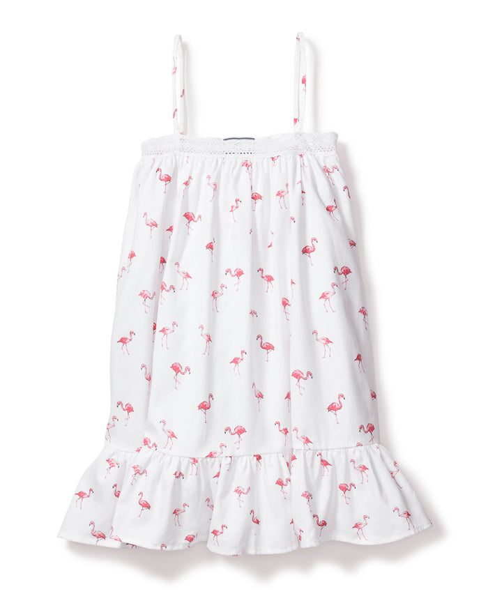 The Girls Twill Lily Nightgown in Flamingos by Petite Plume blends summer charm and cotton comfort. This white sundress features thin straps, a playful pink flamingo pattern, a ruffled hem, and a textured band near the neckline for a breezy yet cozy feel.