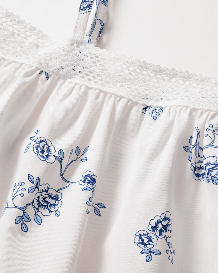 Close-up of the Girls Twill Lily Nightgown in Indigo Floral by Petite Plume, showcasing a delicate vintage blue floral pattern with an elegant white lace trim at the top edge and thin straps.