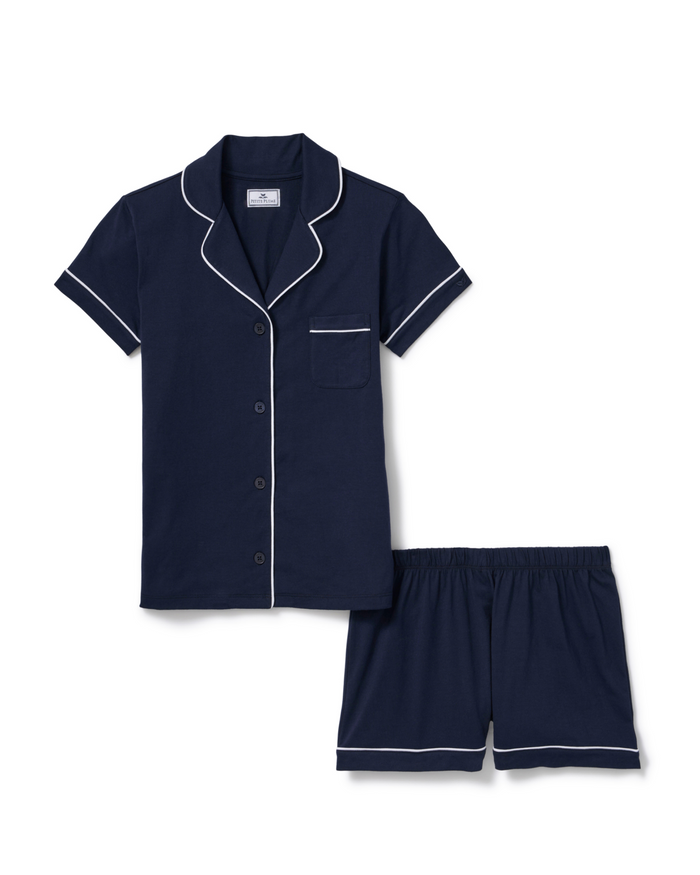 The Poppy Lightweight Pima Short Set in Navy features a navy blue short-sleeve button-up top with white piping and a chest pocket, paired with matching elastic-waist shorts.