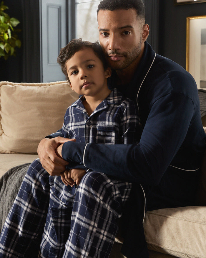 Kid's Brushed Twill Pajama Set in Oxford Tartan, featuring a navy and white plaid long-sleeve button-up top with chest pocket and matching elastic-waist pants, displayed neatly on a white background.