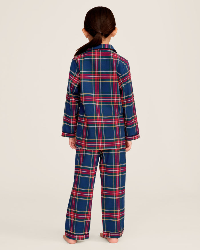 Close-up of a lavish Kids Brushed Cotton Pajama Set in Windsor Tartan by Petite Plume, showcasing red, blue, green, and yellow intersecting stripes forming squares and rectangles. A visible button and seam complete this classic pajama look.