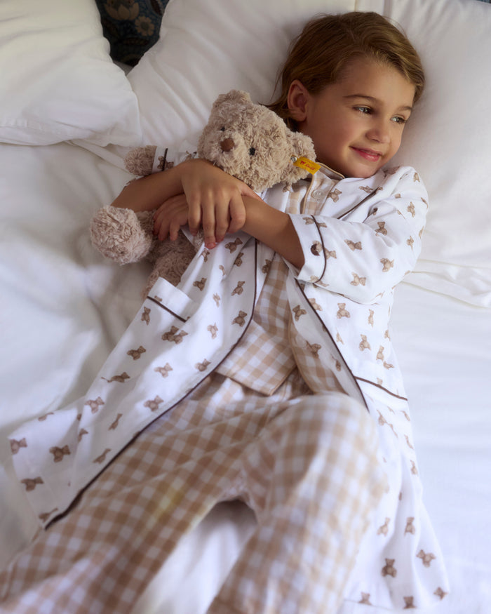 The Kid's Brushed Twill Robe in Teddy Tales features a white base with brown bear prints, black piping, two front pockets, and a matching waist belt.