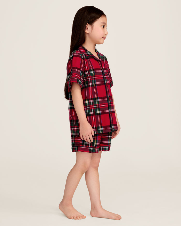 The Kid's Brushed Twill Short Set in Imperial Tartan features red plaid with green, black, and white stripes, including a short-sleeve button-up shirt with a chest pocket and matching elastic waistband shorts.