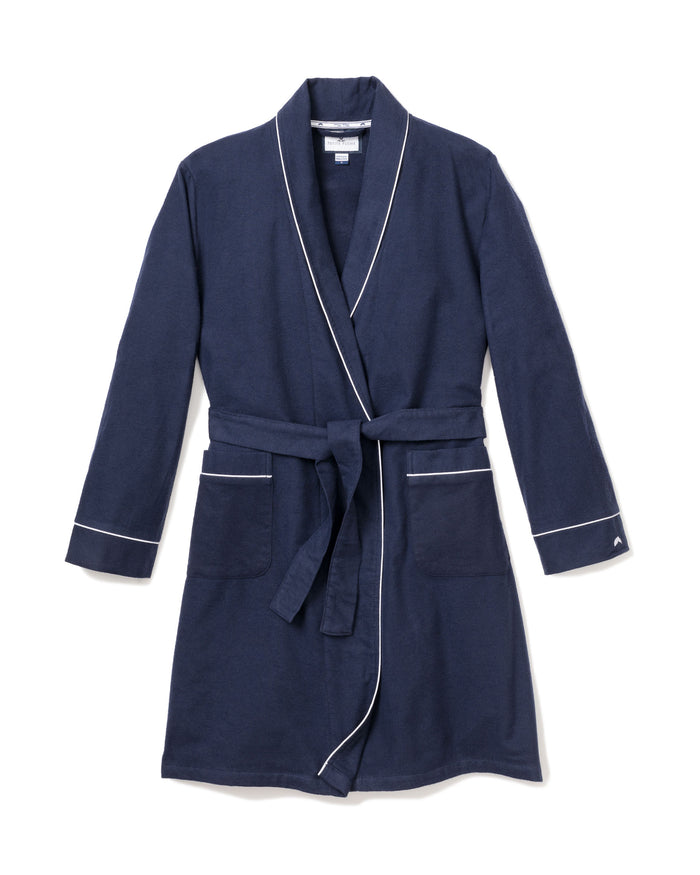 The Kids Flannel Robe in Navy with White Piping by Petite Plume is perfect for childrens sleepwear. It features a belt at the waist, two front pockets, long sleeves, and is made from flame-retardant material for added safety.