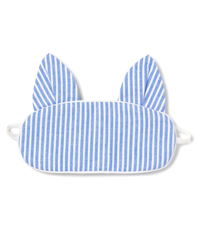 The Kids Kitty Sleep Mask in French Blue Seersucker by Petite Plume features cat-like ears and elastic straps for a snug fit. This playful mask can be monogrammed, making it an ideal gift. Consider matching masks for friends to share the cozy charm.