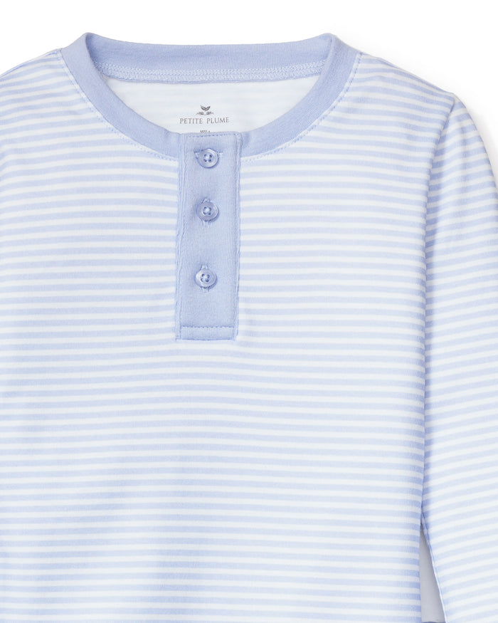 The Petite Plume Kids Pima Snug Fit Pajama Set in Blue Stripes is crafted from soft Pima cotton and includes a light blue and white striped henley shirt with long sleeves and three blue buttons. Perfect for cozy sleepwear, it features an inner collar label for added comfort.