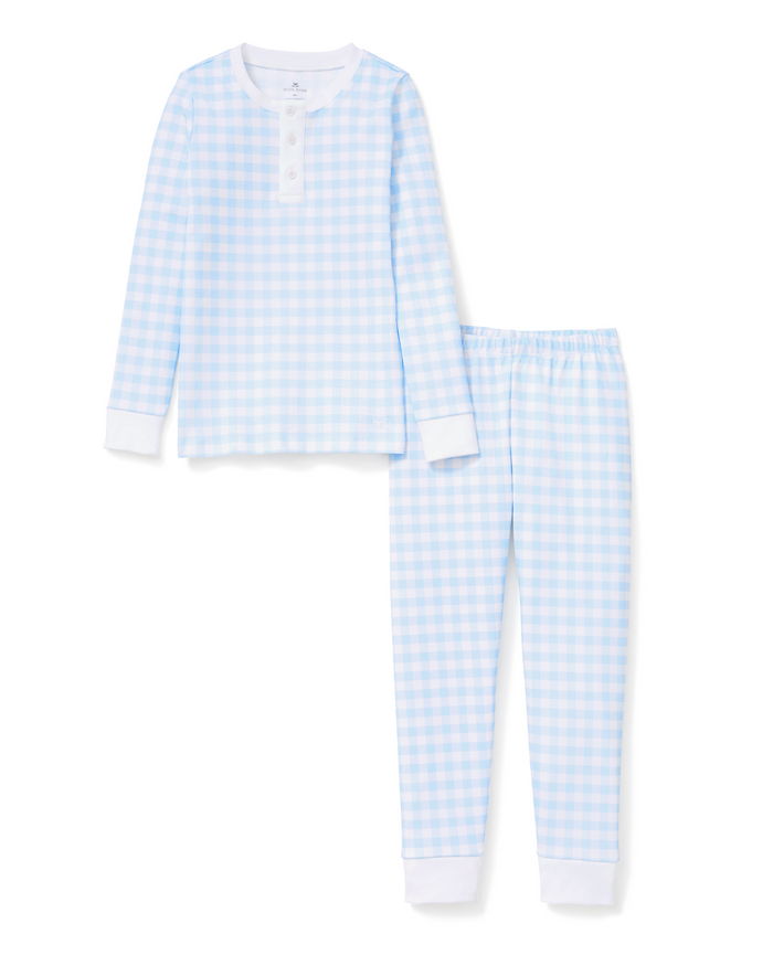 Kid’s Pima Snug Fit Pajama Set in Light Blue Gingham includes long sleeves and pants, showcasing a light blue and white gingham pattern. The set features solid white cuffs and collar, with a buttoned placket at the neckline on the top.