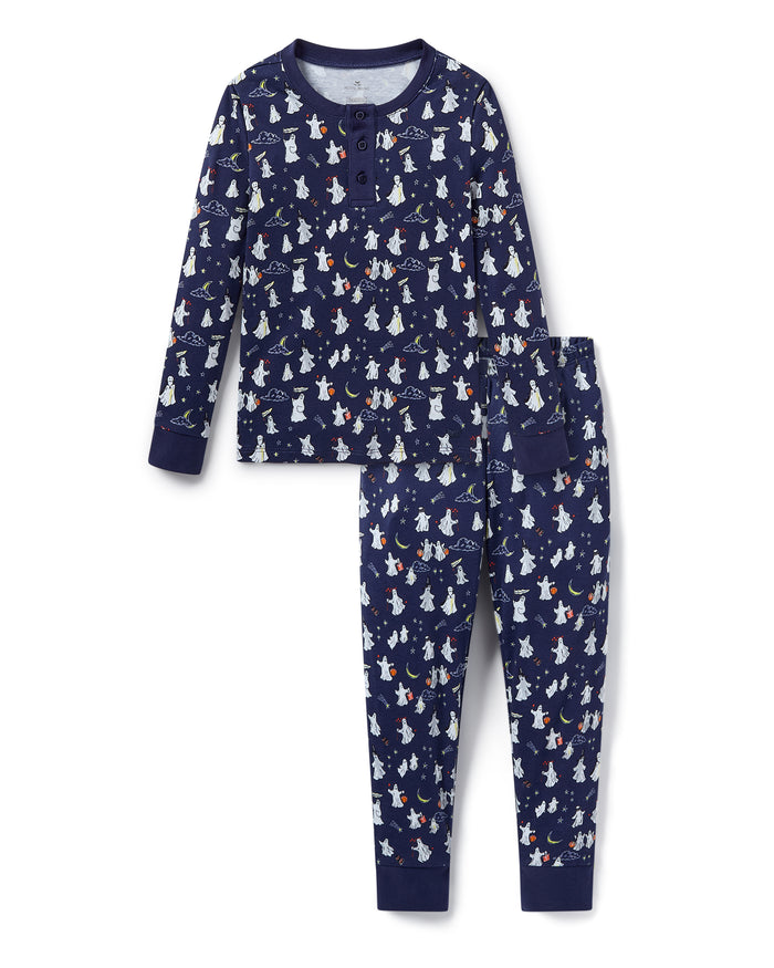 The Kid's Pima Snug Fit Pajama Set in Spooky Slumber is a navy blue pajama set with long sleeves and pants, featuring white and red cartoon dogs in winter gear, plus dark blue cuffs and button details on the top.