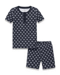 Introducing the Kid’s Pima Snug Fit Short Set in Captain’s Compass: a navy blue short-sleeve pajama set for kids, featuring a white ship wheel pattern. The top includes a round neckline and button placket, while the matching shorts offer an elastic waistband for comfort.